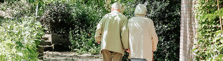 older couple one with a cane walking together