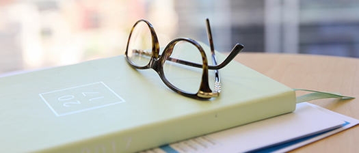 A pair of reading specs resting on a book