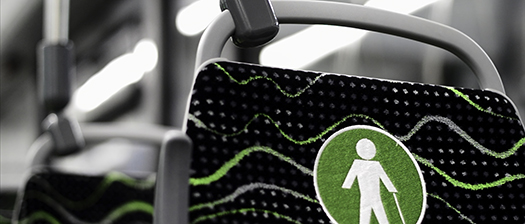 Close up of a back rest on a public transport bus with an illustration of a person using a walking stick