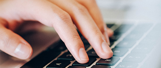 Person typing on a laptop keyboard