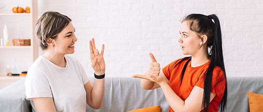 two people on sofa using sign language