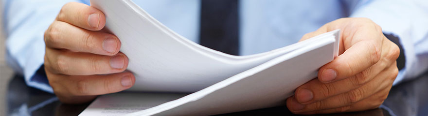 A close up of a person holding a pile of documents