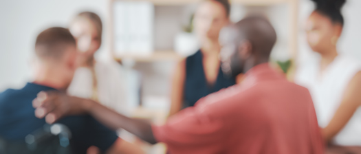 An out of focus image of a group of people sitting in a counselling session