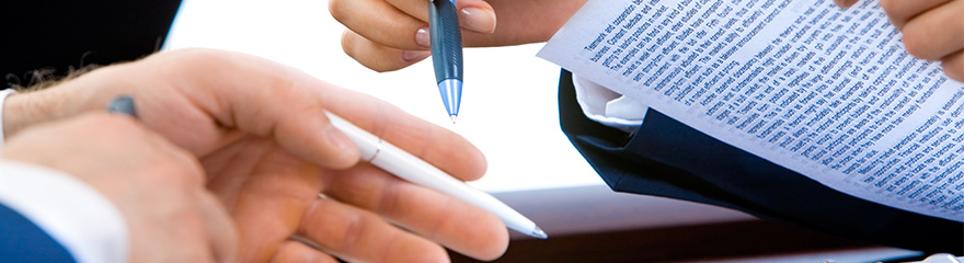 Close up of two peoples hands, one person is holding a pen and paper