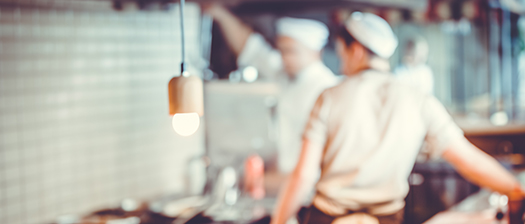 An out of focus photo of kitchen staff in a commercial kitchen