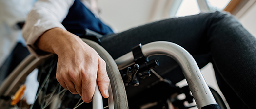 Close up of hand holding onto wheel of wheelchair