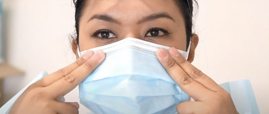 A close up headshot of a support worker donning a PPE surgical mask